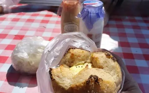 牧歌の里のパン屋で売られているパン。テーブルの上にパンと便の牛乳とコーヒーが置かれている。