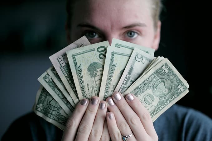 お金の札を持つ女性のアイキャッチ画像