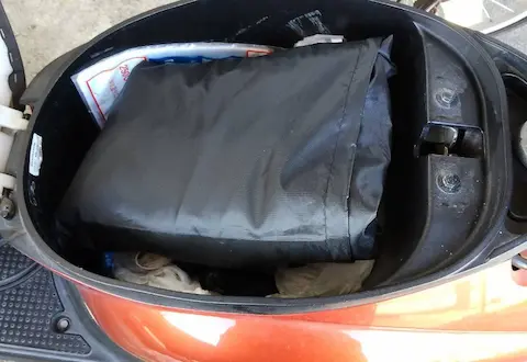 メットインに収納袋に入ったバイクカバーが収納されている様子。