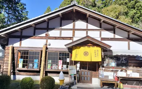 岐阜県中津川市にある食事処『樹梨』の外観。和風の木造建築に黄色い暖簾がかかっている。