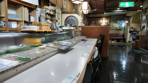 岡山の海鮮屋「ふく仙」の店内。カウンター席が写っている。