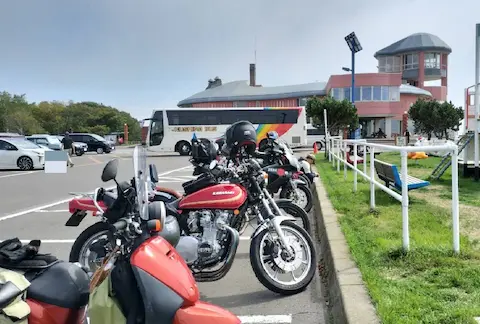 道の駅厚岸グルメパークの外観。バイク駐車スペースから外観を見ており、バイクがたくさん並んでいる。