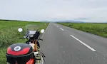 北海道の猿払エヌサカ線。草原に囲まれた真っすぐの道路と原付。
