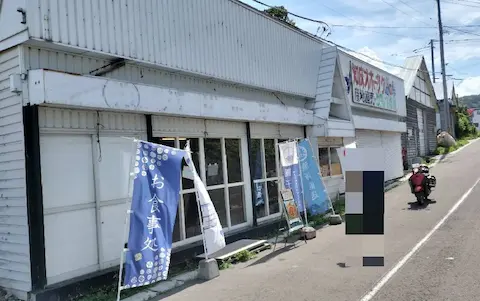 斜里町ウトロの圓子水産店舗外観。オレンジの原付もうつっている。
