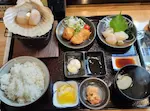 紋別の寿司処みらくのホタテ御膳。焼き、フライ、刺身、三升漬けのホタテと、ご飯類のセットが並ぶ。
