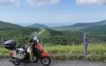 知床横断道路と原付トゥデイ。高い位置から山々と峠道が見れる。