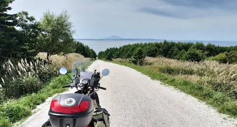 北海道宗谷丘陵にある白い道。真っすぐ伸び、奥に海と利尻富士が見える。