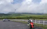 知床峠展望台駐車場とオレンジ原付のトゥデイ。羅臼岳が雲に隠れている。