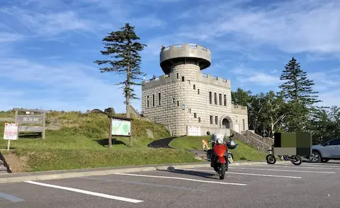 津別峠展望台の外観。タワー上の展望台と原付がうつっている。