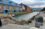 小樽運河の景色。運河沿いにレトロな建物が並ぶ。スーパーカブのフランとが少し写っている。